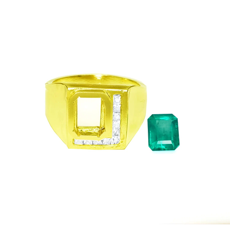 Gold ring with square design and embedded diamonds, next to an emerald gemstone.