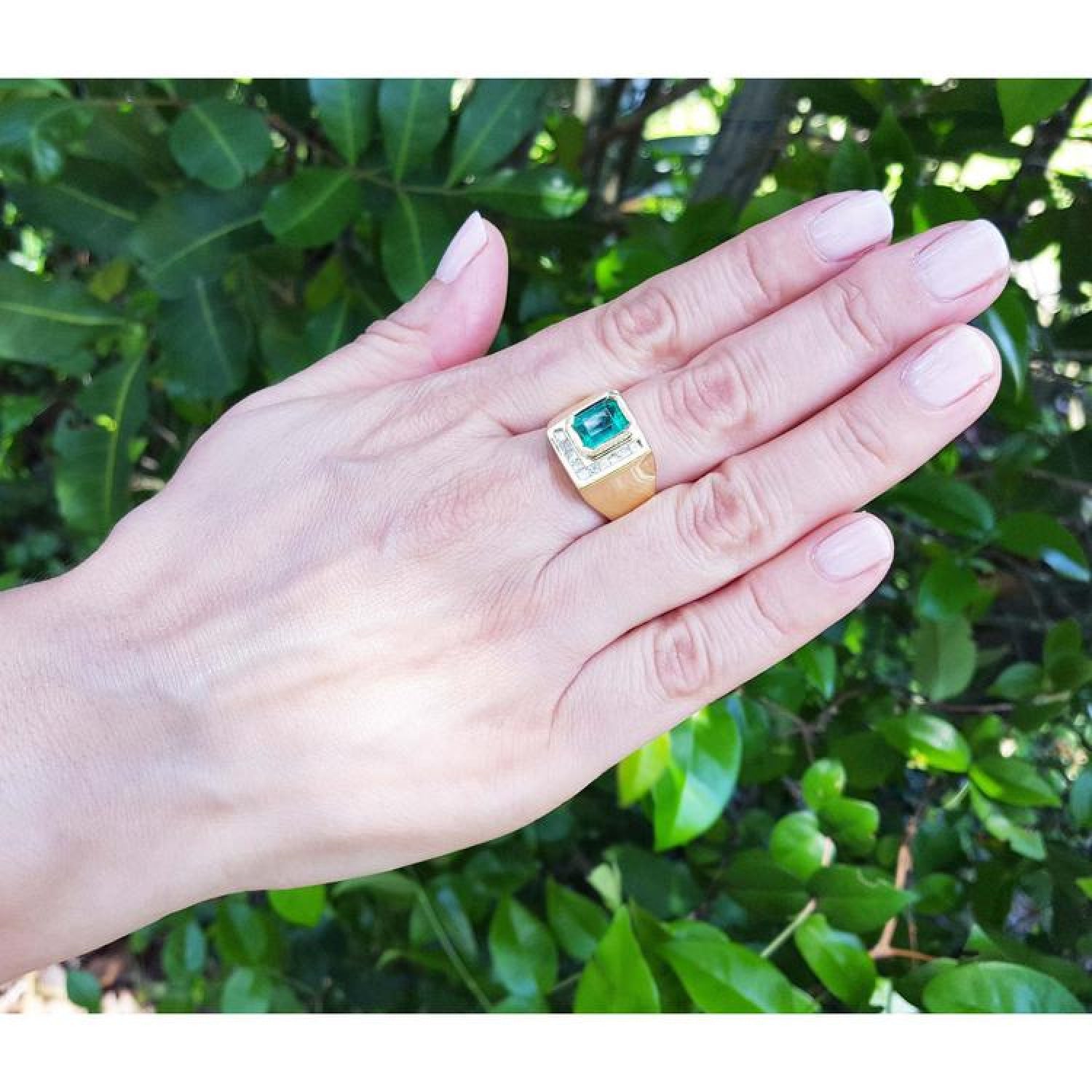 Men's 18K yellow gold ring with a rectangular Colombian emerald and channel-set princess-cut diamonds.