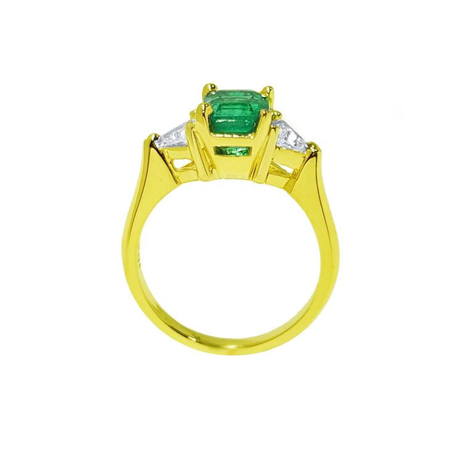 1.27 ct natural Colombian emerald three-stone ring in 18K yellow gold with trillion diamonds.