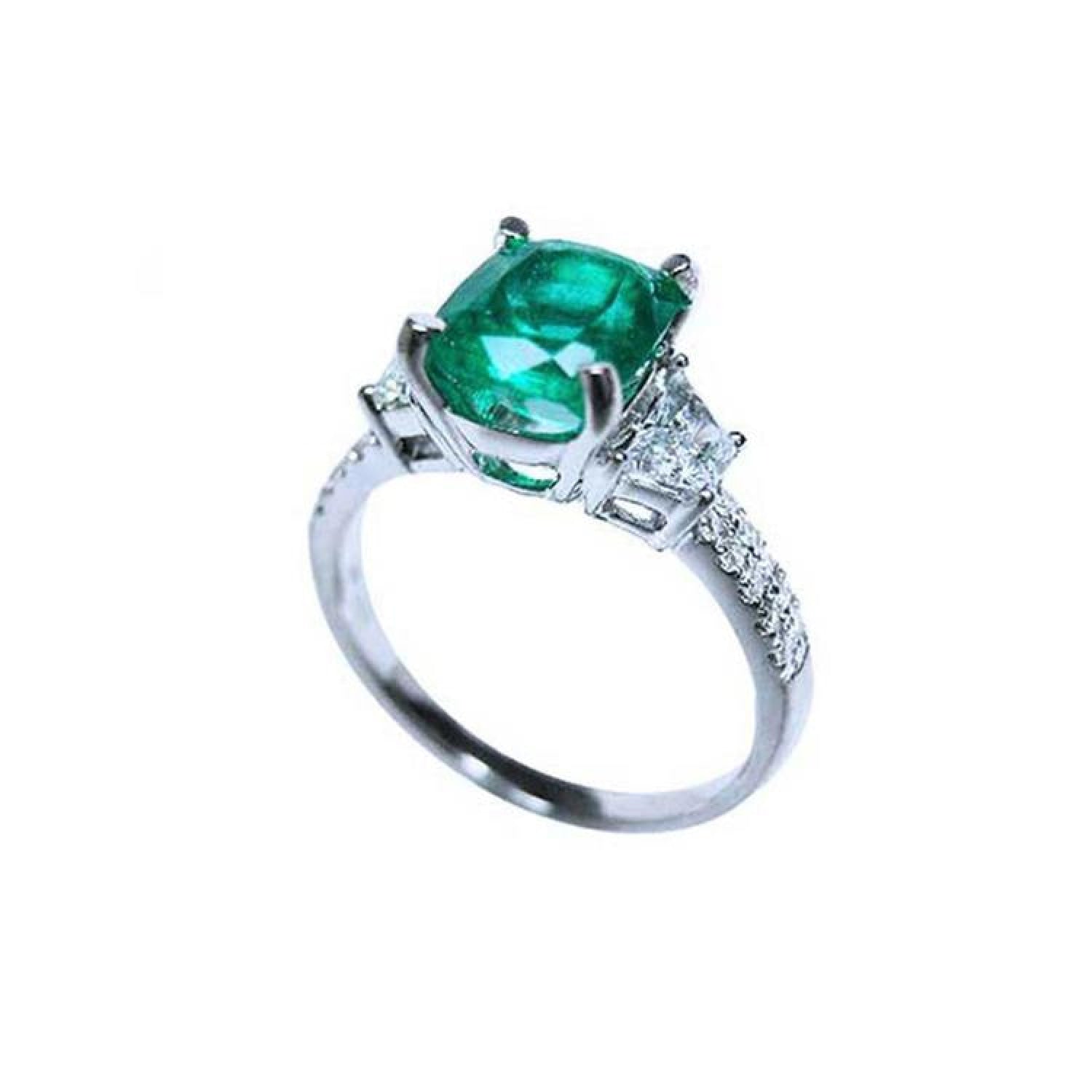 18K white gold ring with a cushion-cut emerald and trapezoid side diamonds.