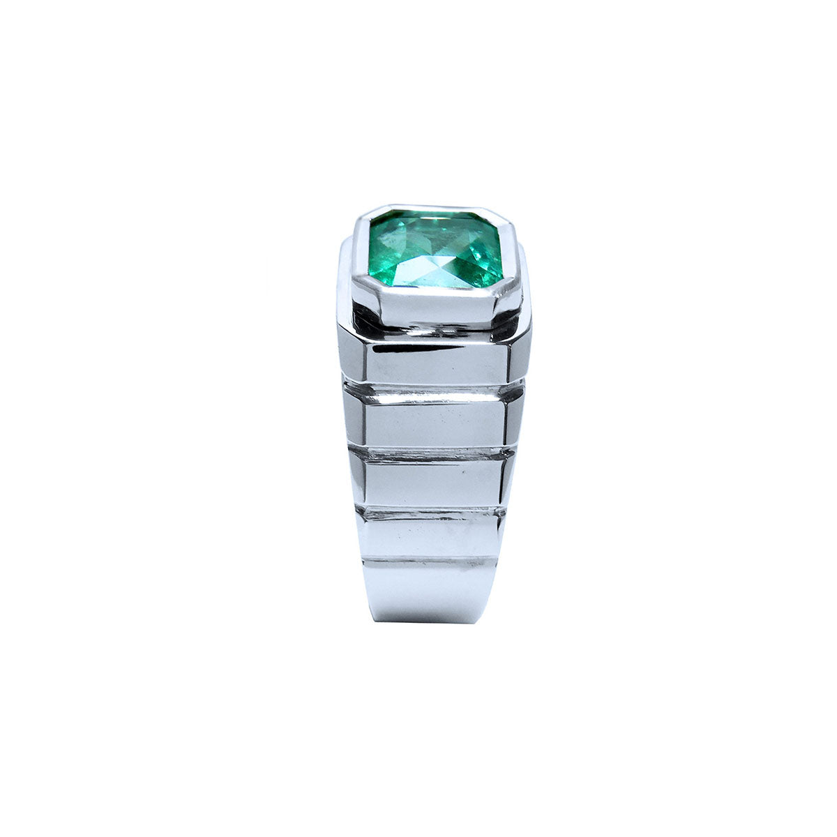 Side profile top bezel setting and band design of this white gold emerald ring for men are displayed.