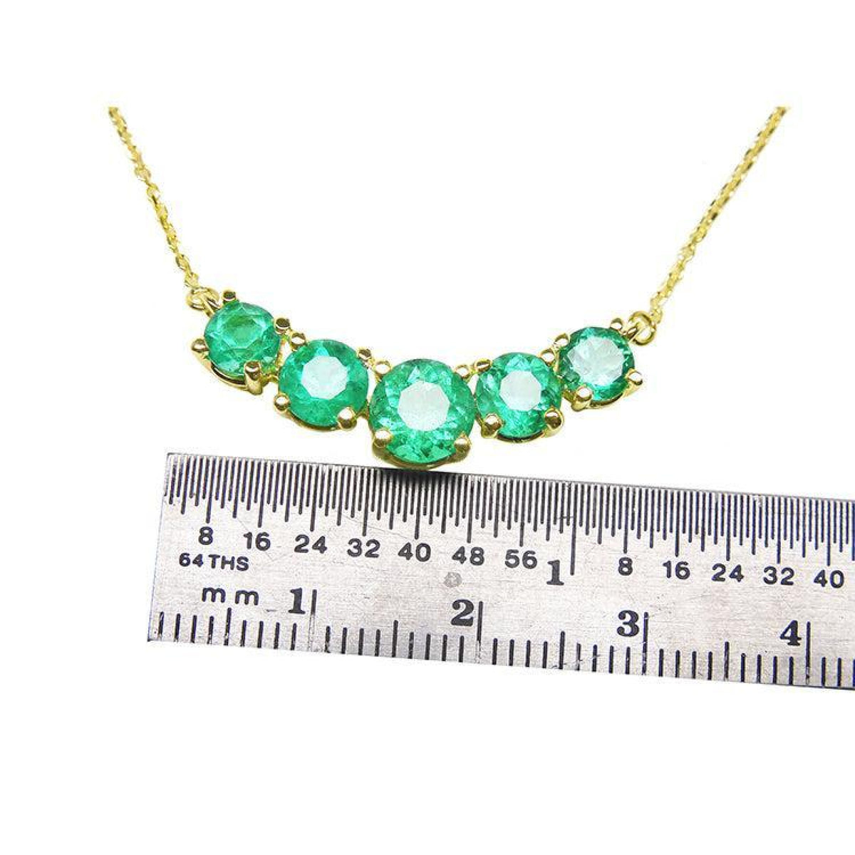 14K gold necklace with five round, medium green Colombian emeralds, measured by a ruler.
