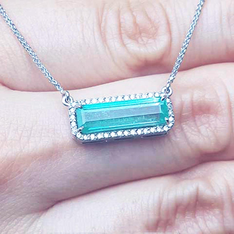 Muzo Colombia Emerald necklace 3.48 carats east west orientation encircle by halo diamonds crafted in 18k white gold