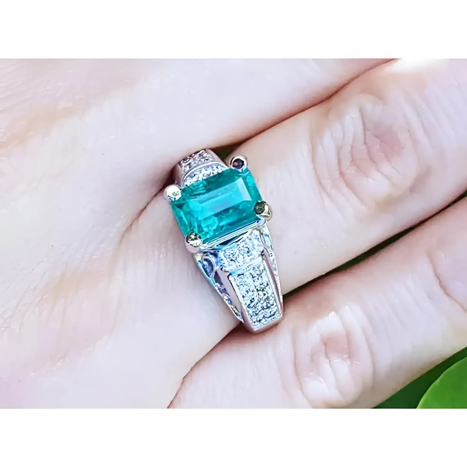 Anillo de mujer con esmeralda colombiana verde profundo y diamantes en oro blanco de 18K, estilo antiguo.