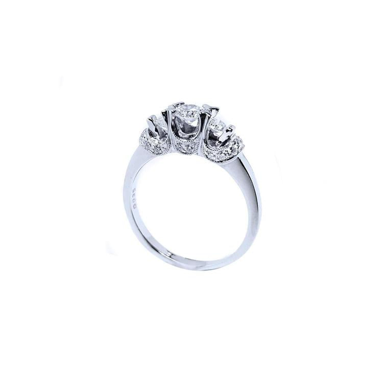 14K white gold three-stone engagement ring with round cut diamonds and pave set accents.