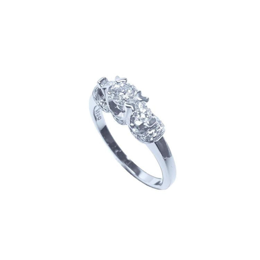 14K white gold three-stone round cut diamond engagement ring with pave set accent diamonds.