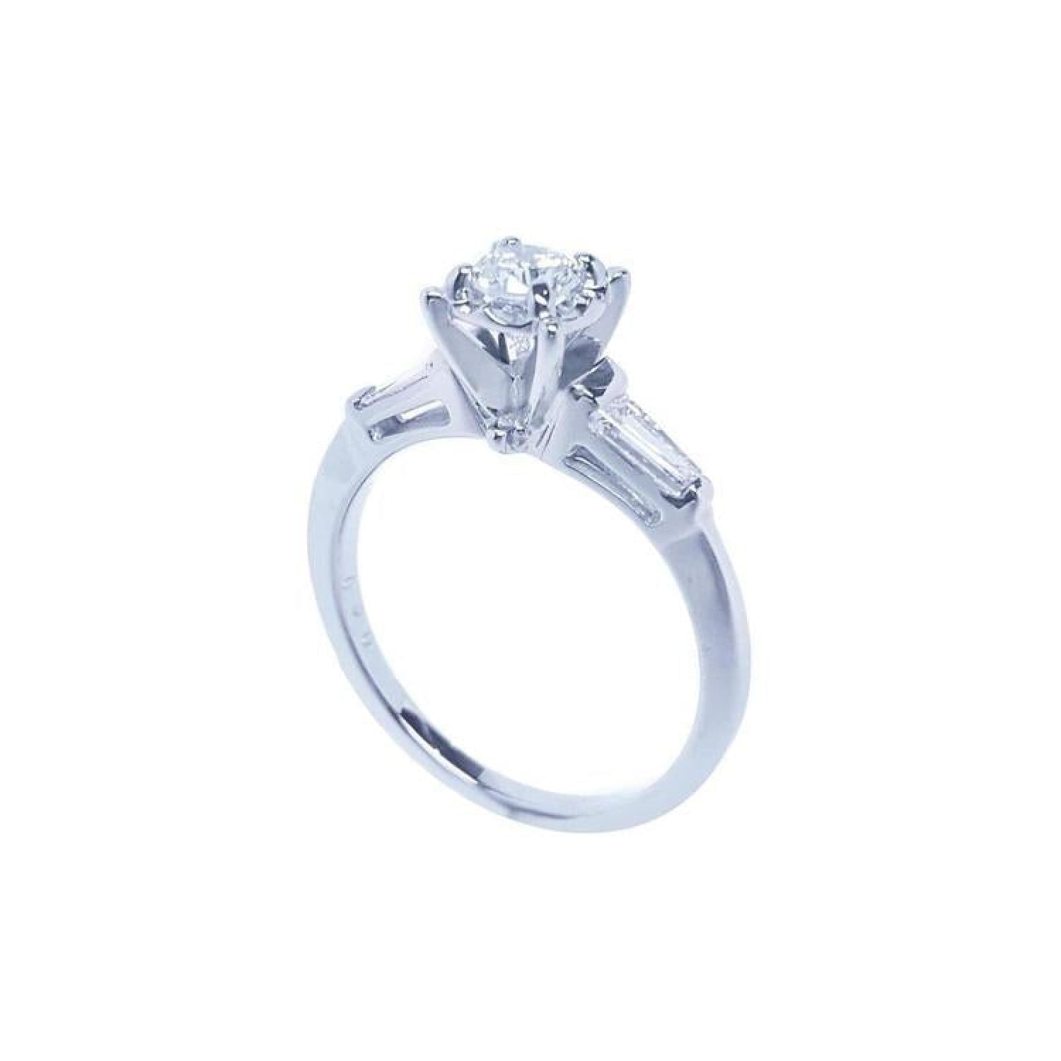 14k white gold engagement ring with a round central diamond and baguette side diamonds.