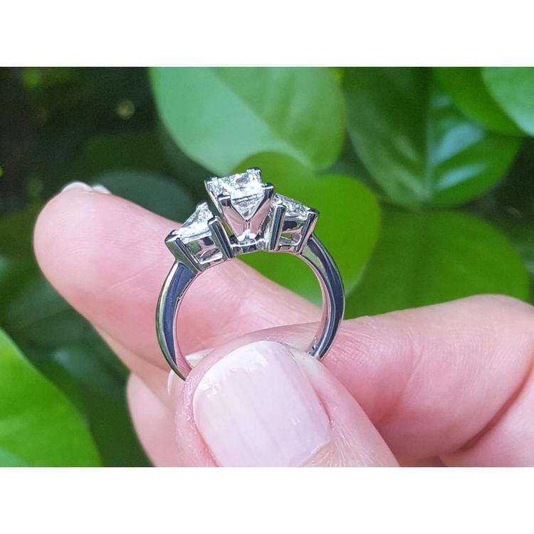 14K white gold ring with a princess cut diamond center and two trillion side diamonds.