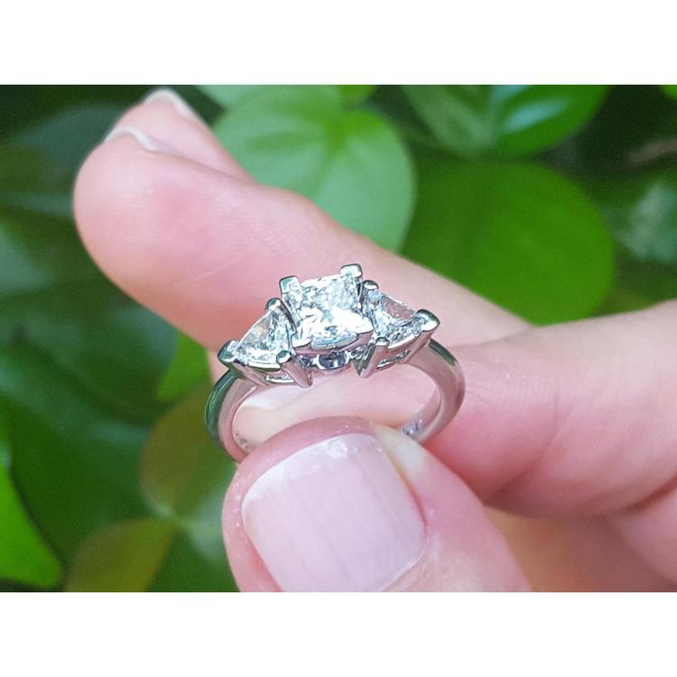 14K white gold ring with a princess cut center diamond and two trillion side diamonds.