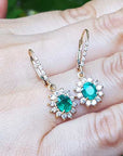 Oval cut emerald dangle earrings