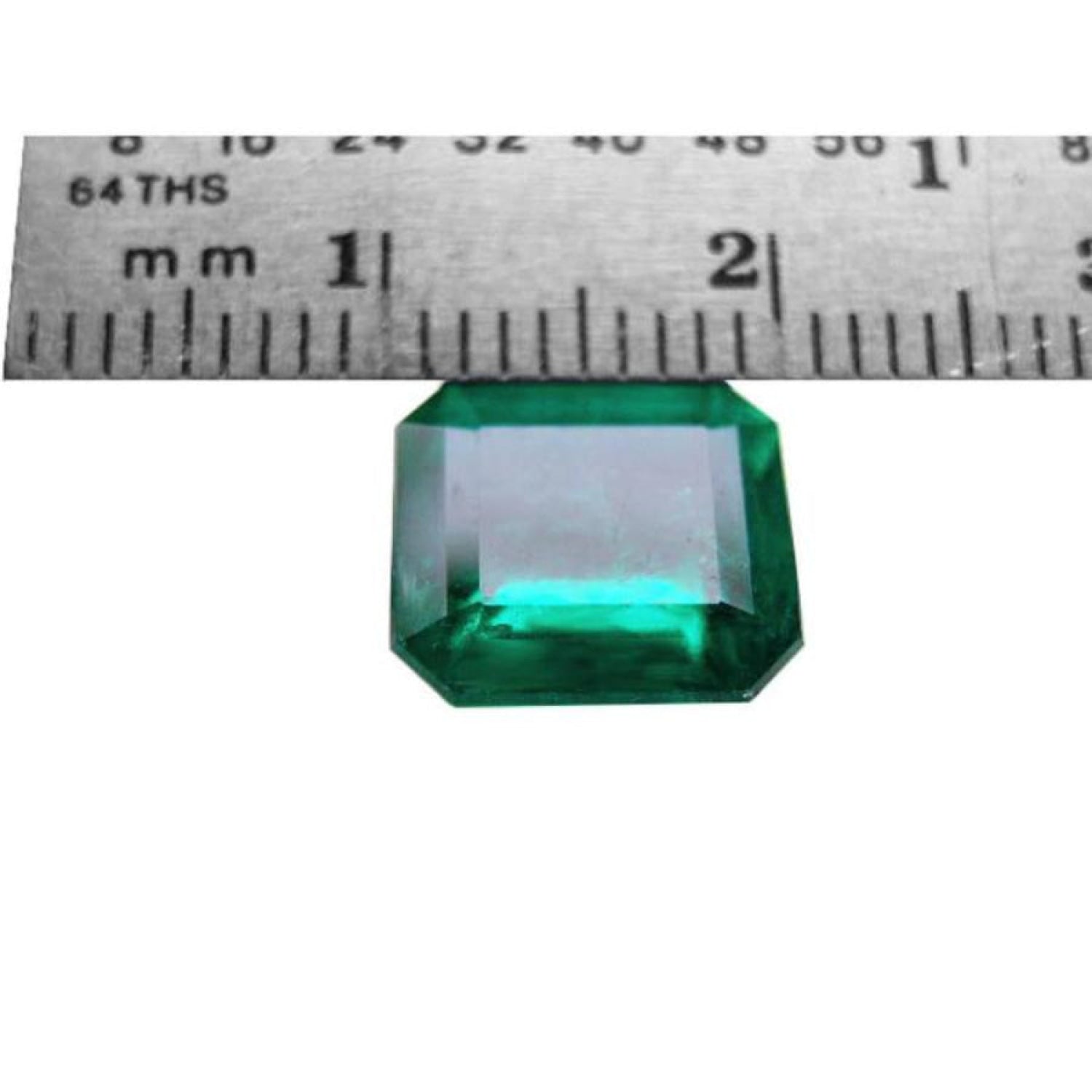 GIA certified 3.55 ct. emerald-cut Colombian emerald gemstone, measured against a ruler.