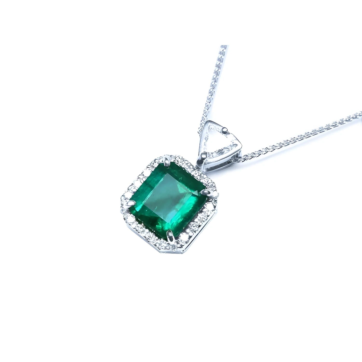 Emerald cut Colombian emerald pendant in 18K white gold with diamond halo and bail.