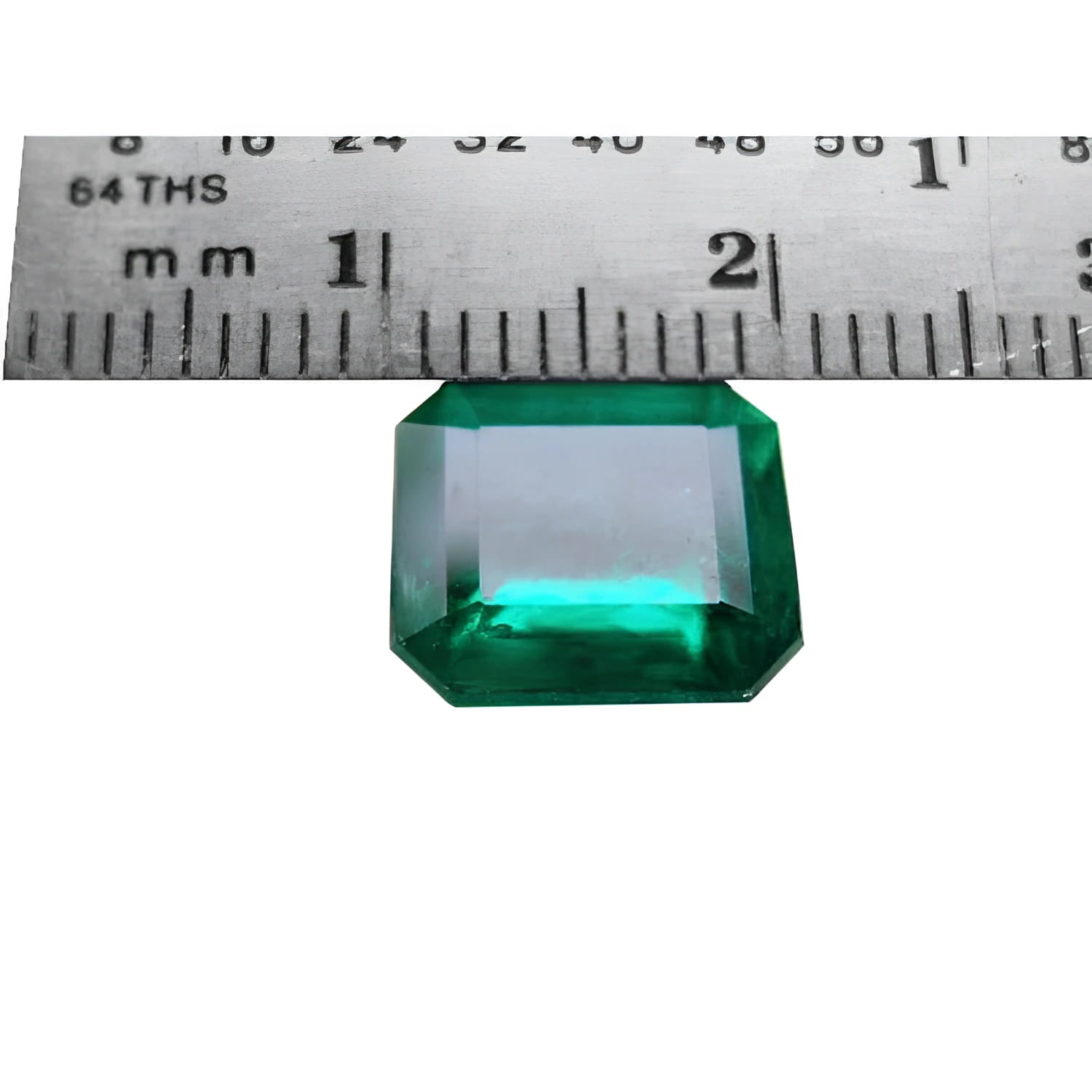 GIA certified 3.55 ct. emerald-cut Colombian emerald gemstone, measured against a ruler.