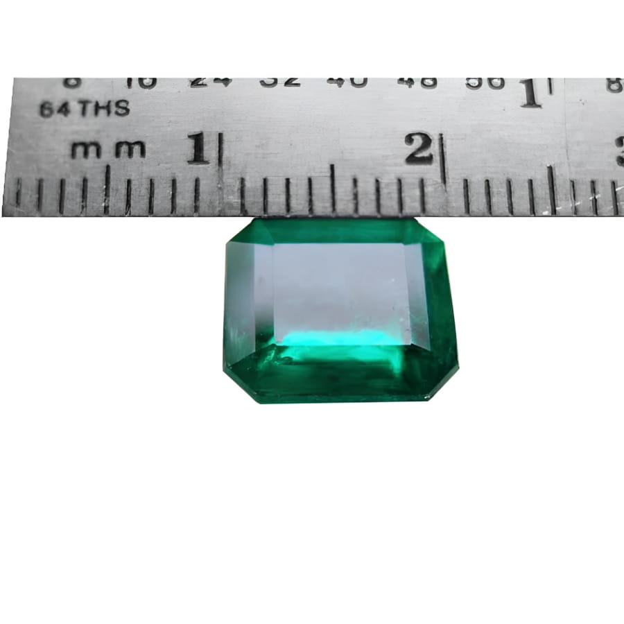 GIA certified 3.55 ct. emerald-cut Colombian emerald gemstone, measured against a ruler.
