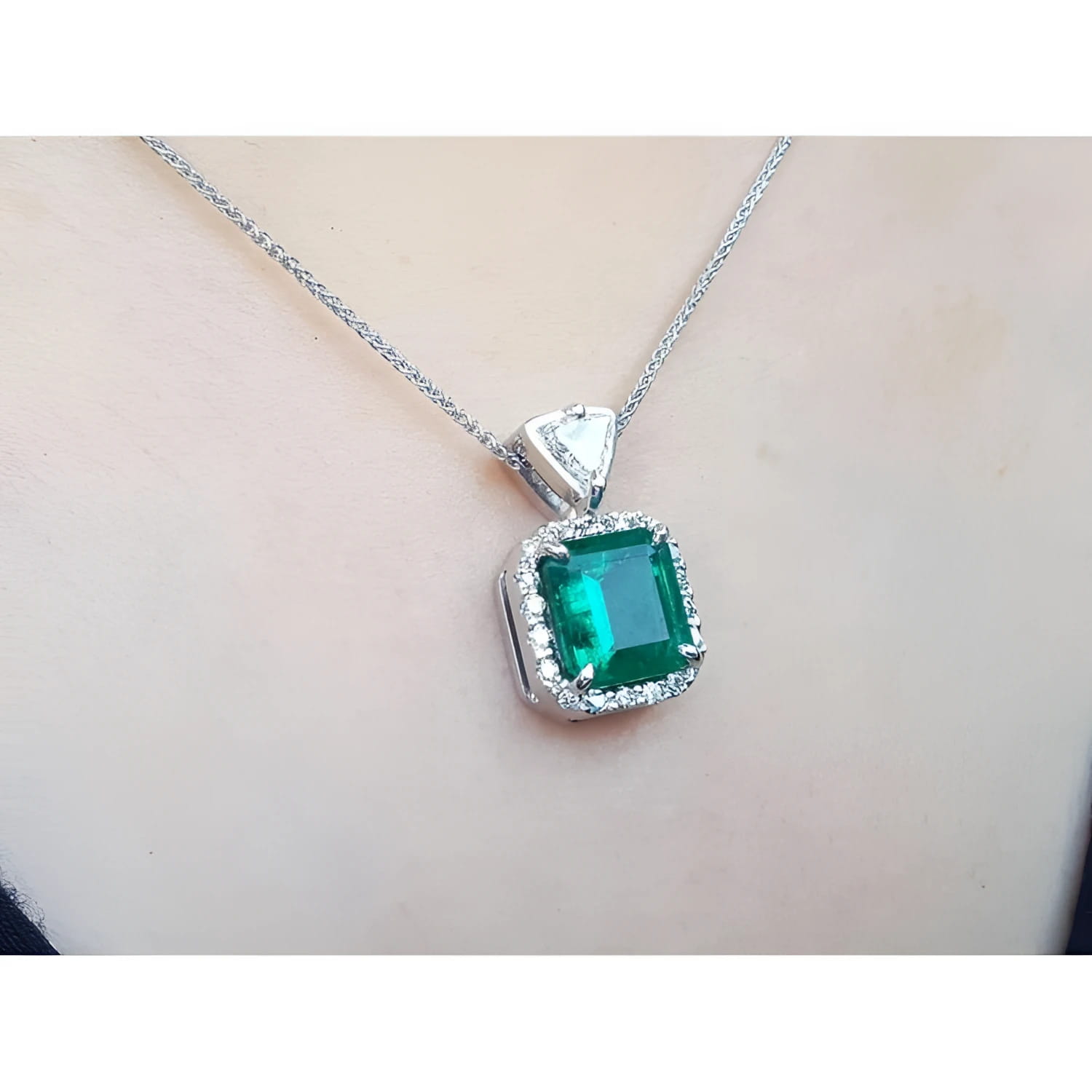 GIA certified Colombian emerald pendant in 18K white gold with diamond halo.