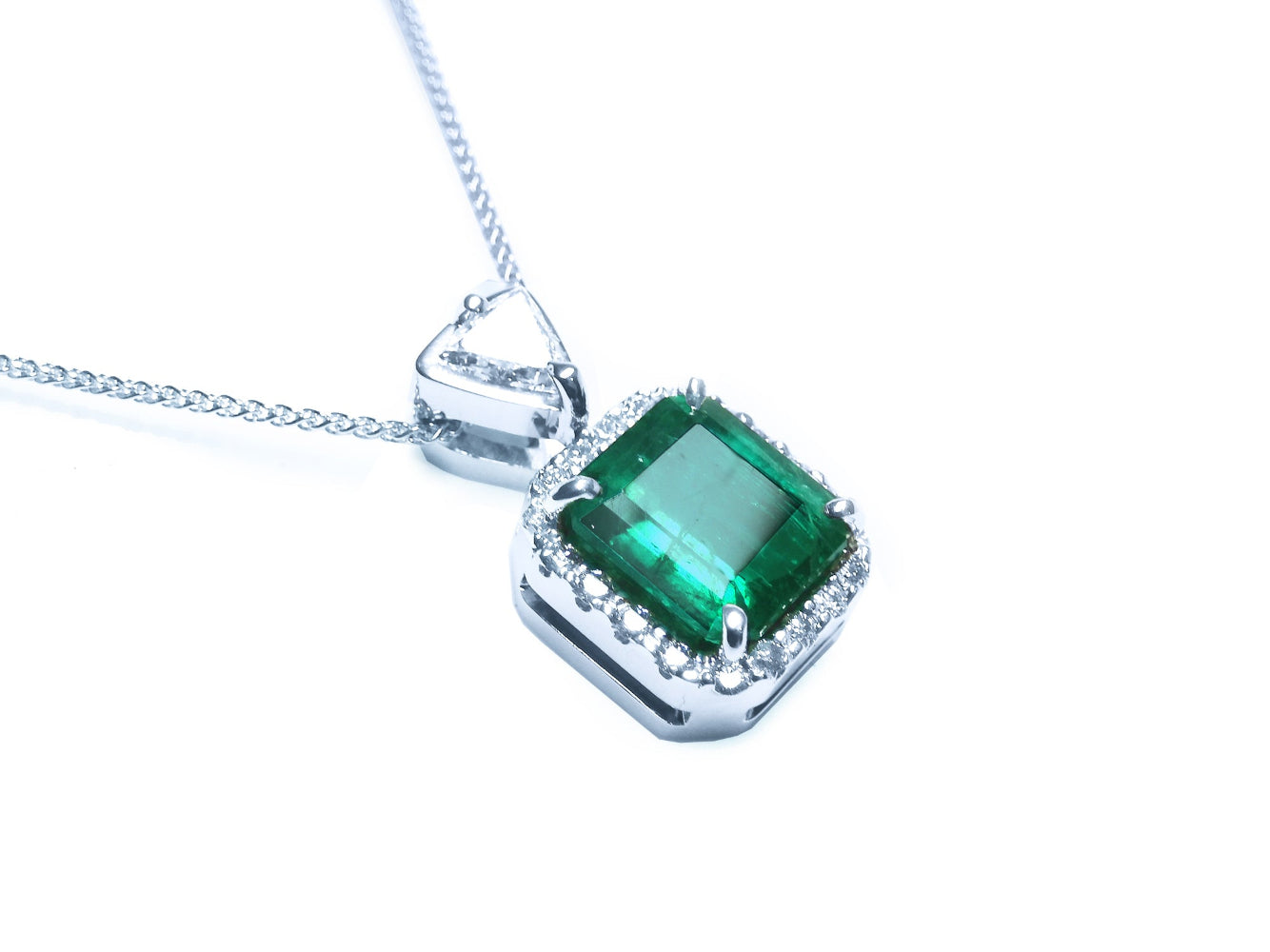 Top and gallery profile view of a natural emerald pendant in 18k white gold.