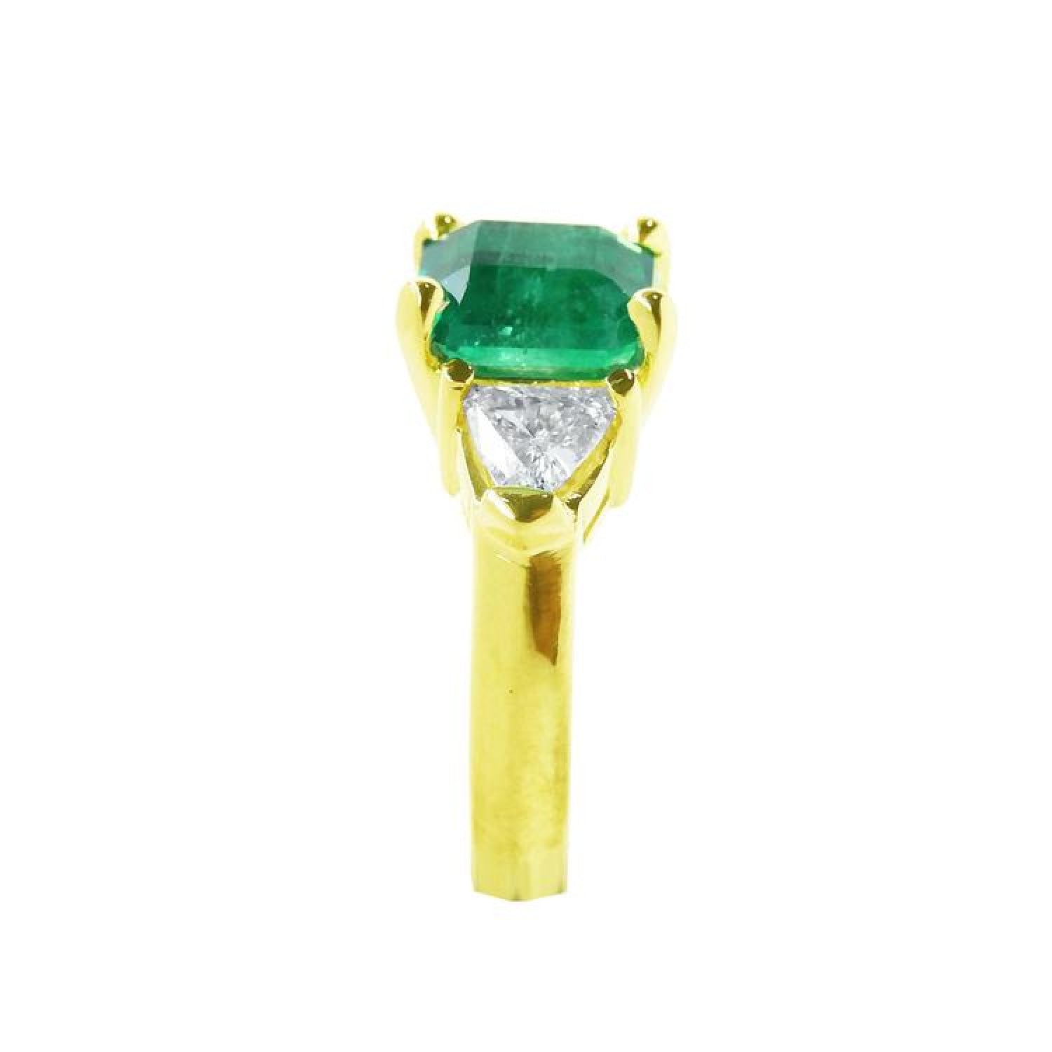 18K yellow gold ring with a GIA certified emerald and side trillion diamonds.