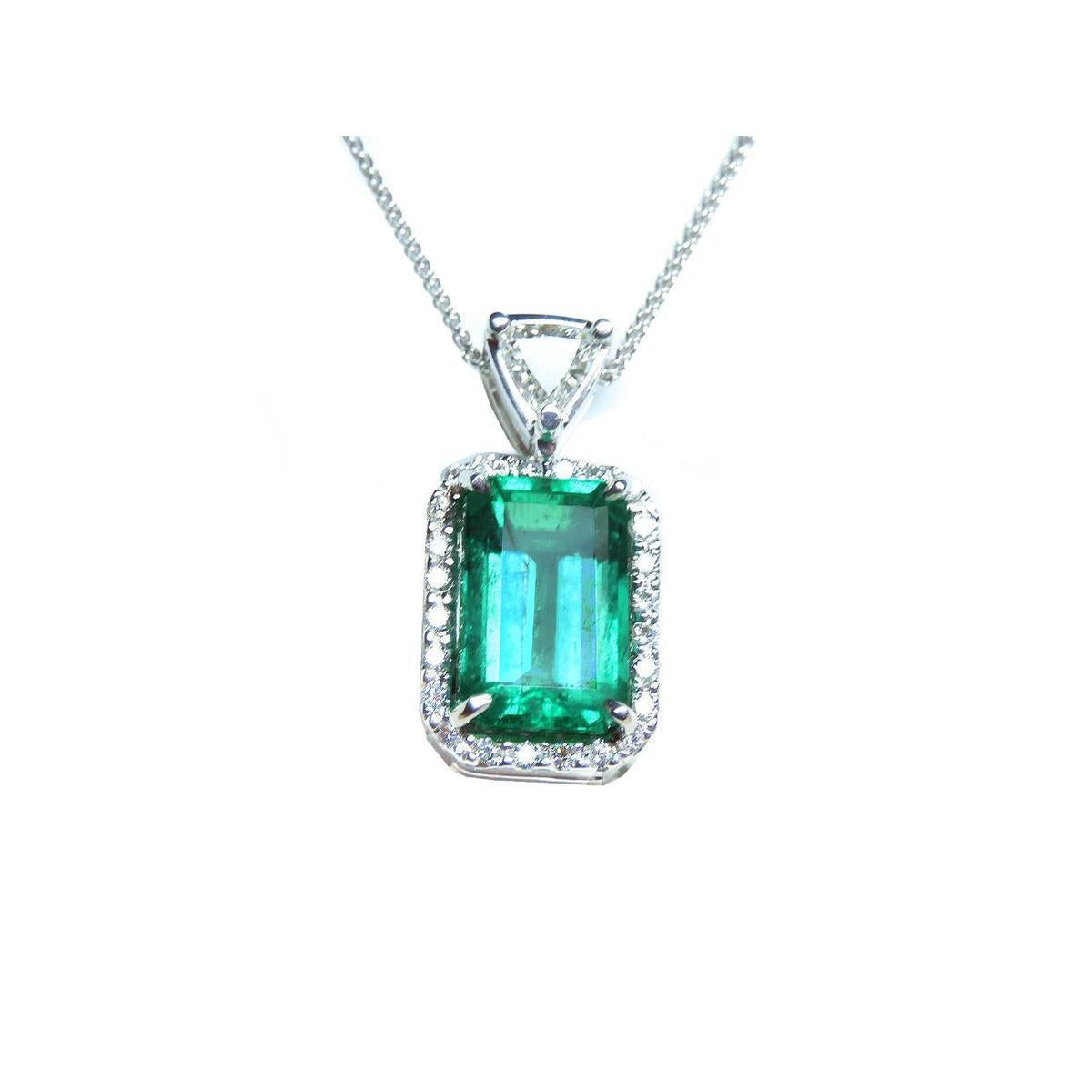 The topside of this certified natural emerald pendant shows the top bail slider with a trillion-cut diamond and the emerald with a halo diamond.
