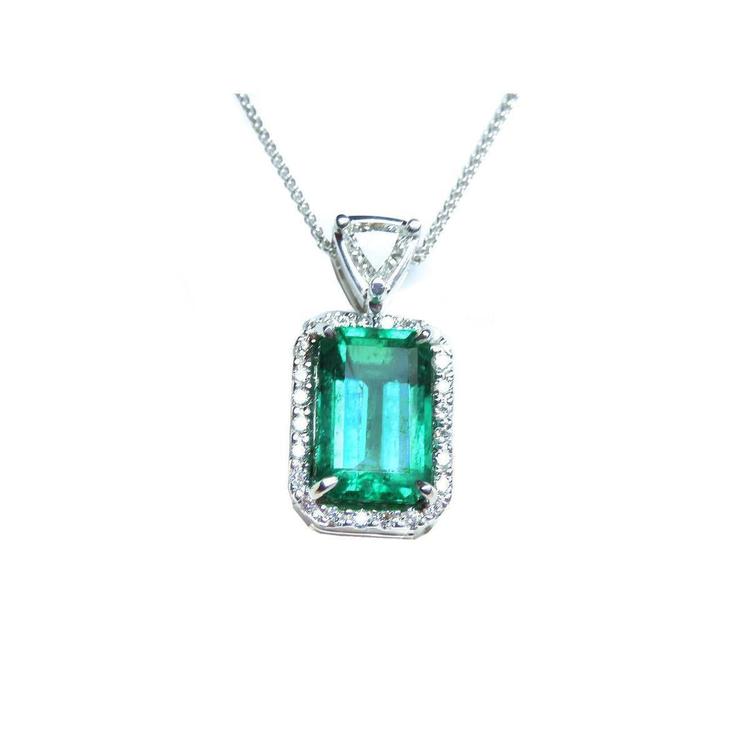 The topside of this certified natural emerald pendant shows the top bail slider with a trillion-cut diamond and the emerald with a halo diamond.