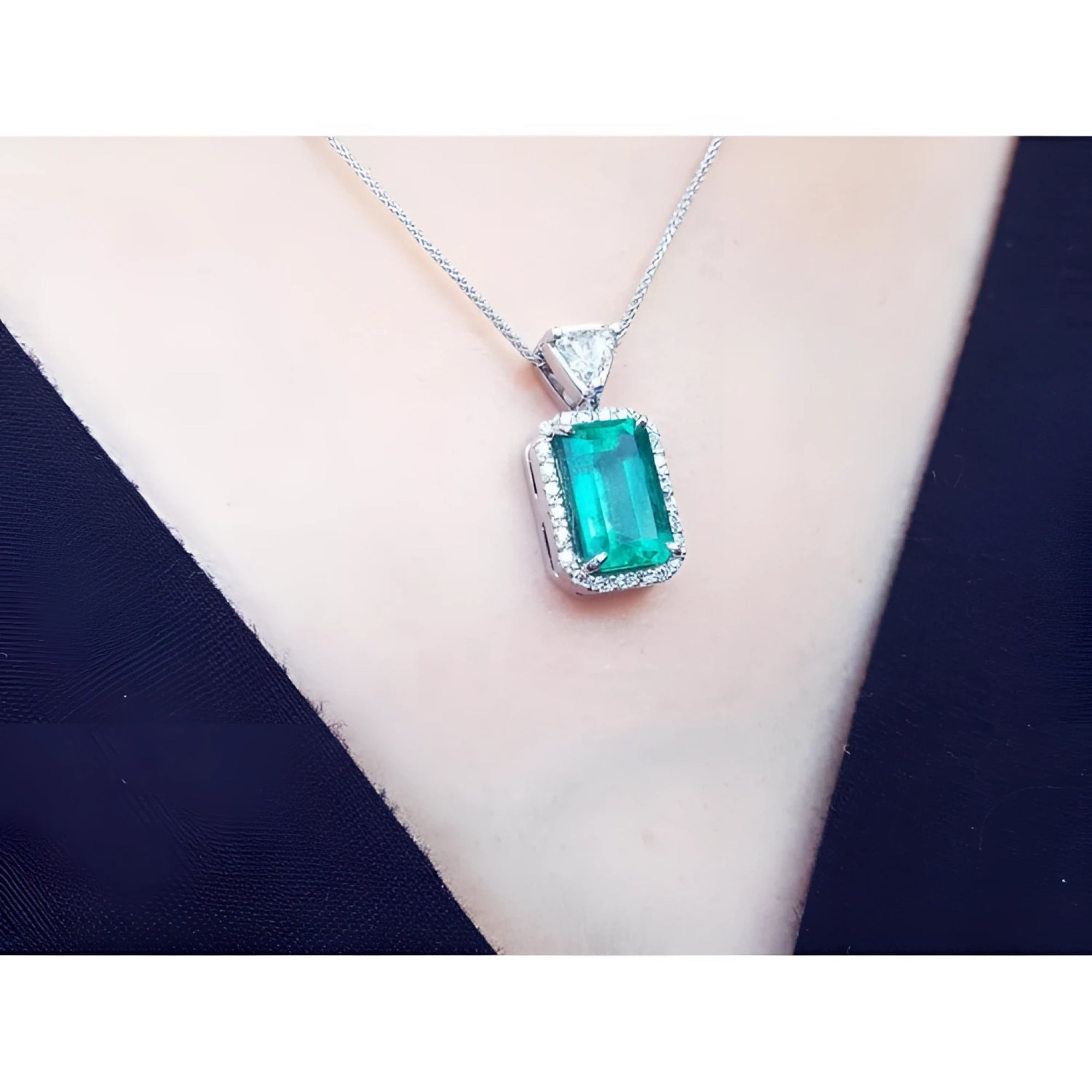 GIA certified 5.65 ct. medium-deep green Colombian emerald pendant with halo diamonds on an 18K white gold chain.