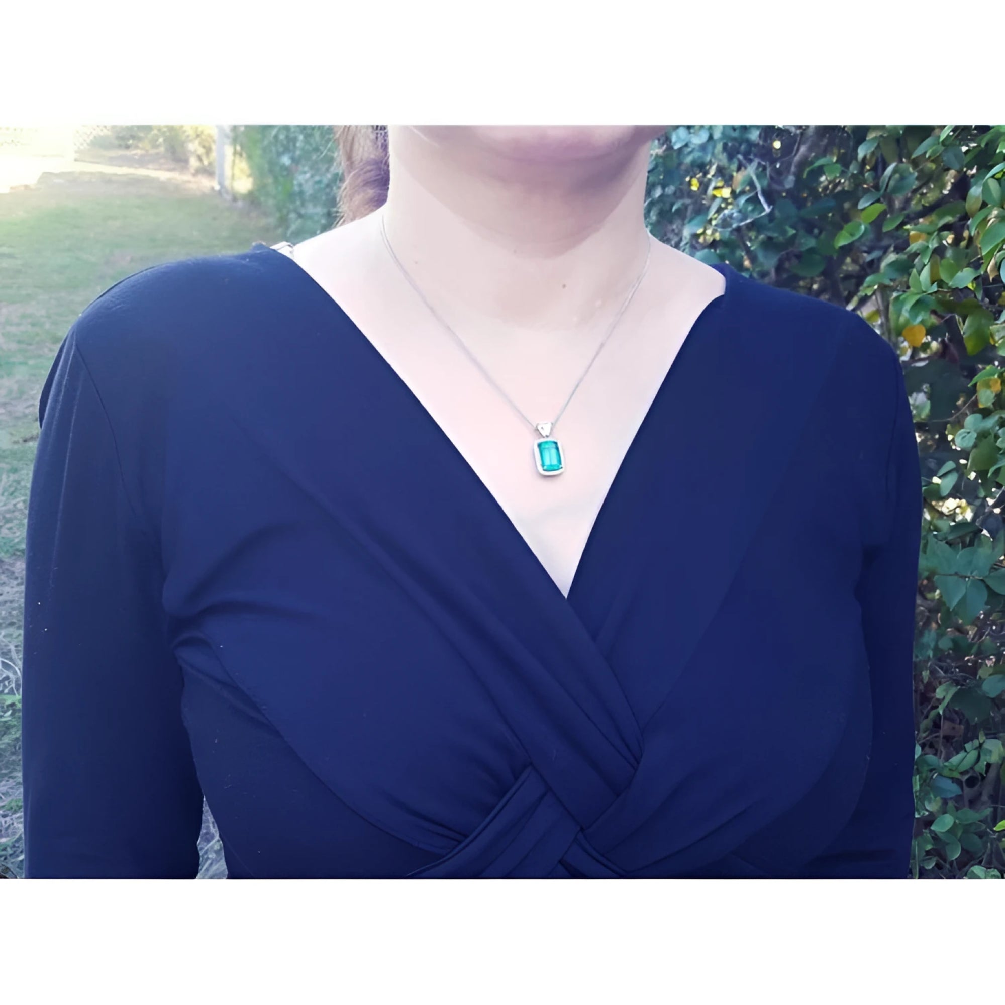 GIA certified 5.65 ct. medium-deep green Colombian emerald halo diamond pendant on 18K white gold chain.