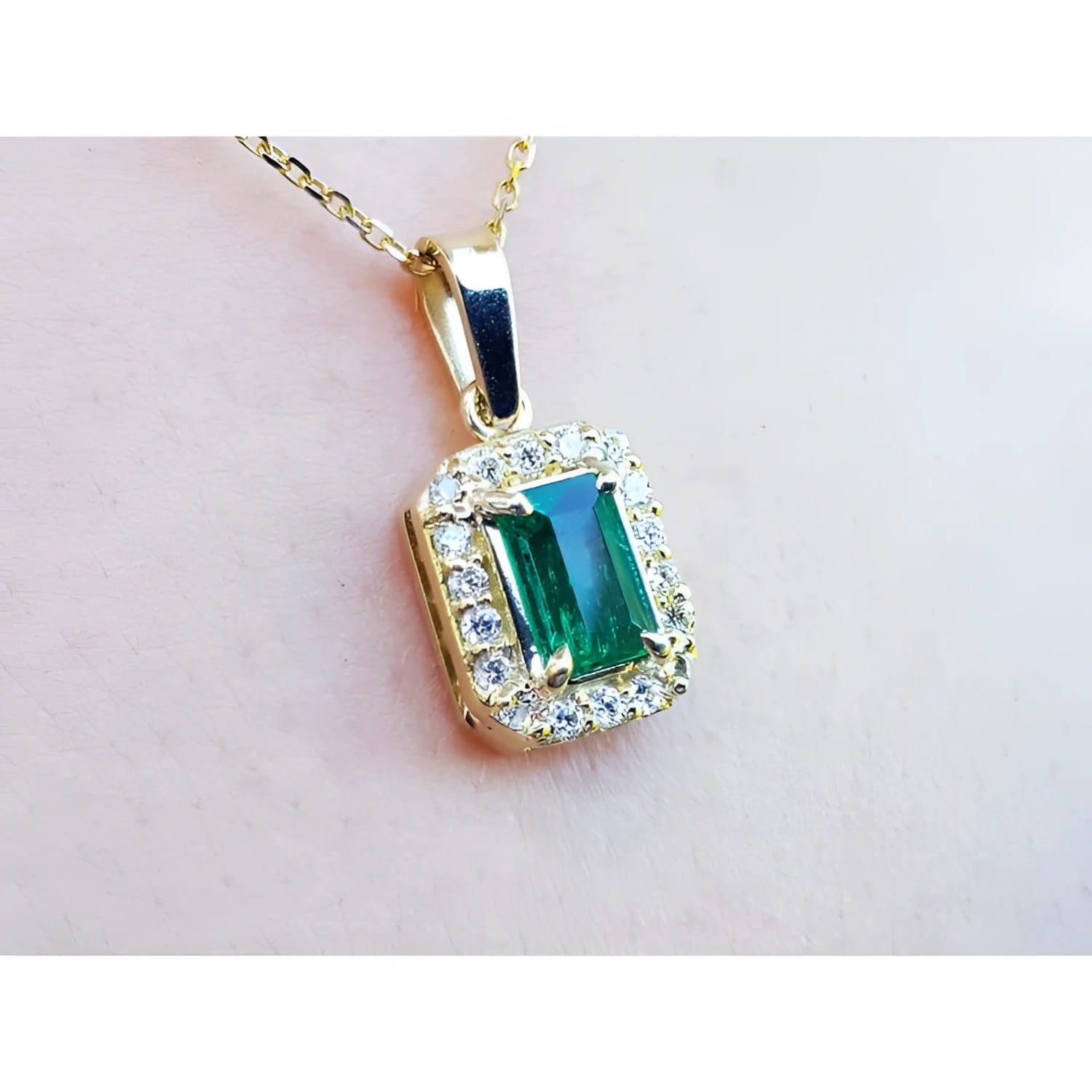 0.75 ct. GIA certified F1 Colombian emerald pendant with diamond halo in 18k yellow gold.