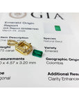 0.75 ct. GIA certified F1 Colombian emerald pendant in 18k gold with diamond halo, next to a loose emerald and GIA report.