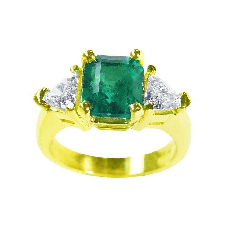 A natural Muzo colombian emerald ring GIA certified with side trillion cut diamonds made of 18k yellow gold.