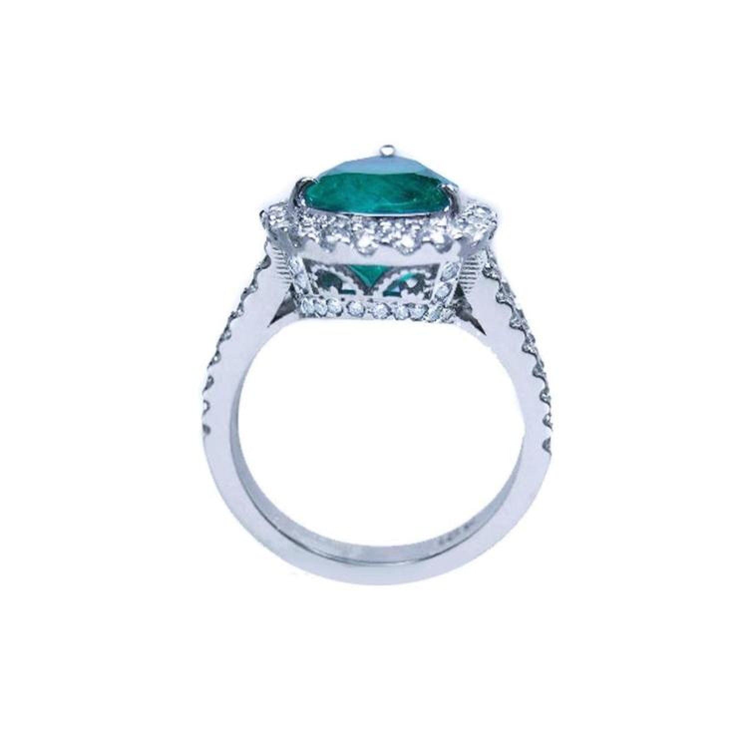 18K white gold ring with a large pear-shaped emerald surrounded by sparkling diamonds.
