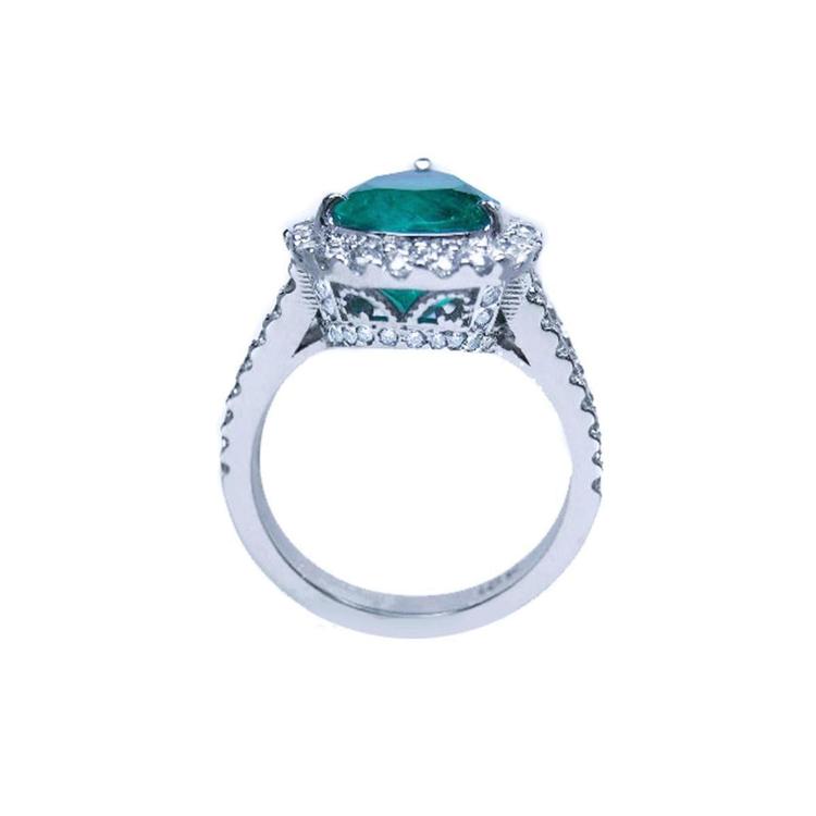 18K white gold ring with a large pear-shaped emerald surrounded by sparkling diamonds.