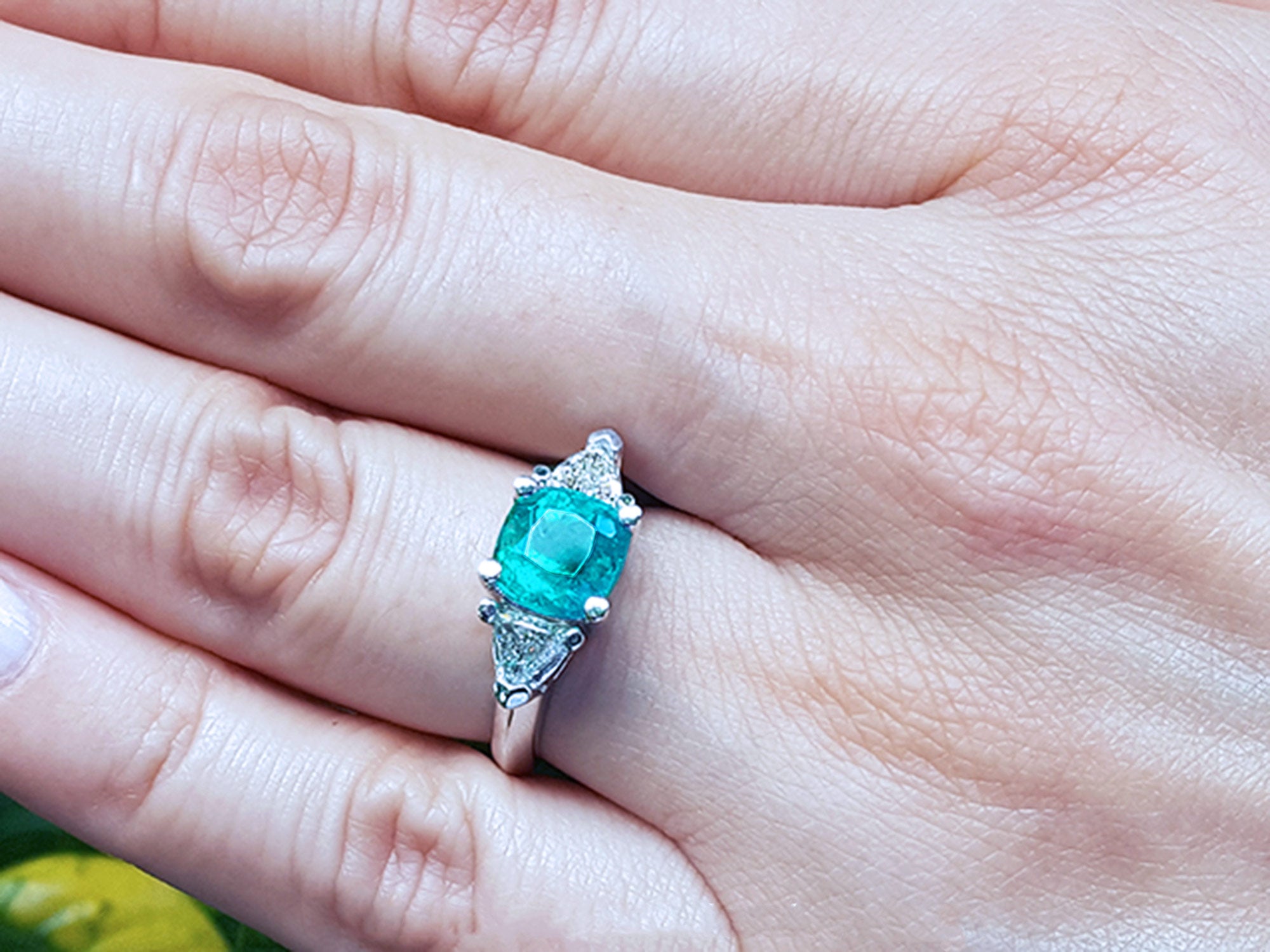 Ladies emerald ring cushion cut and trillion side diamonds