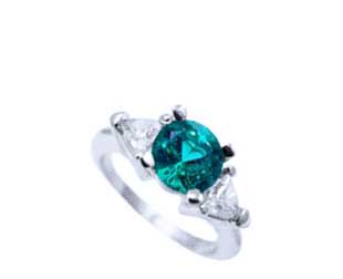 Round cut emerald engagement ring and trillion diamonds