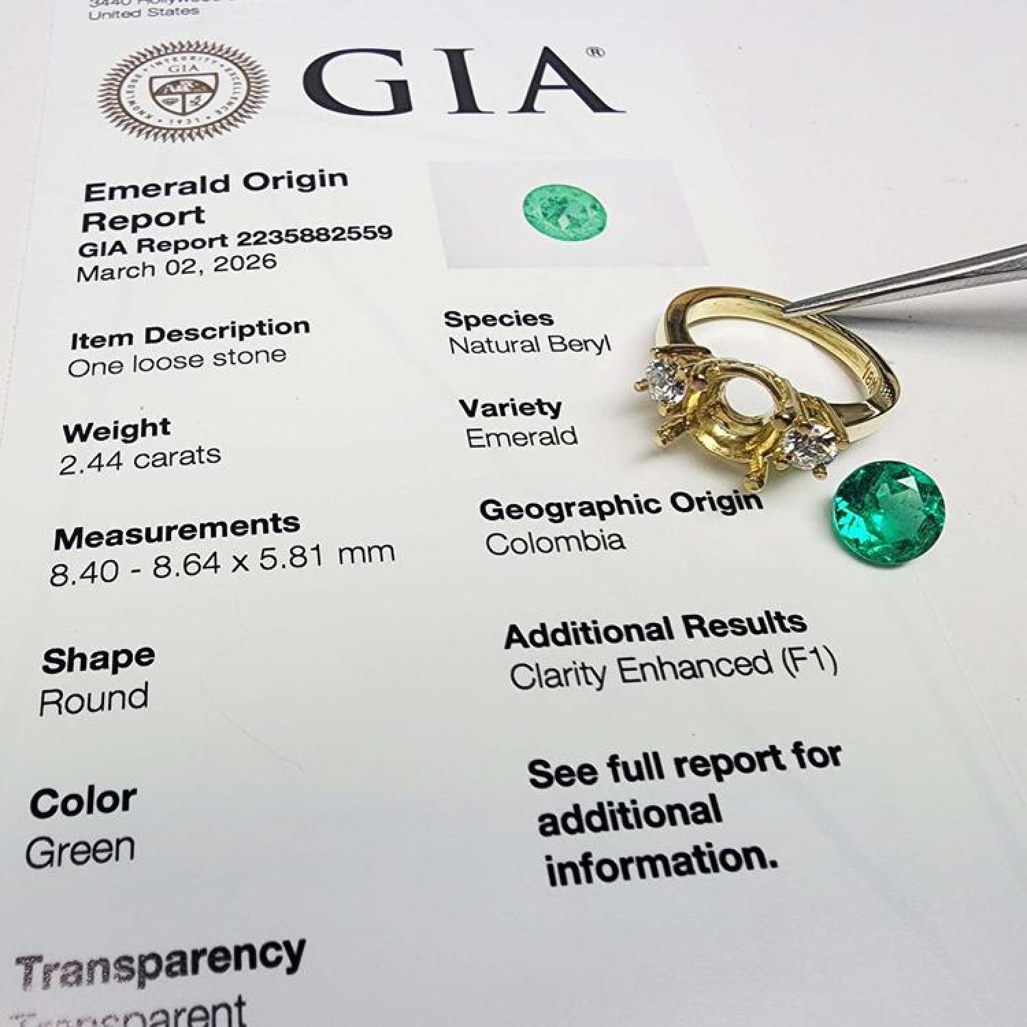 GIA certified 2.44 ct. round Colombian emerald, 18K yellow gold three-stone ring setting with accent diamonds.