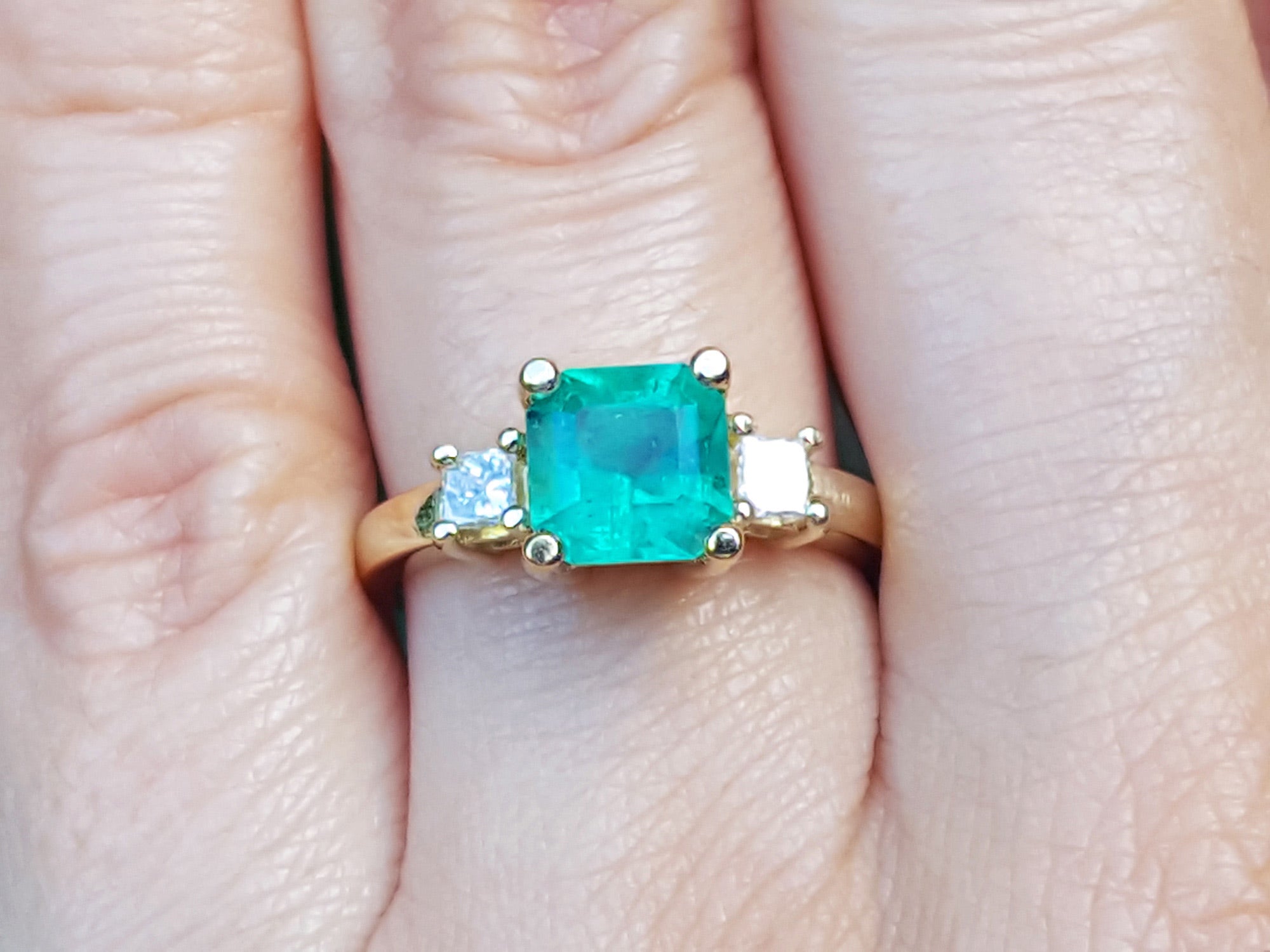 Three stone emerald engagement rings for women