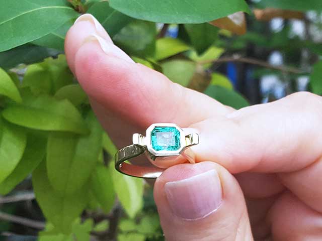 Solitaire emerald ring bezel set