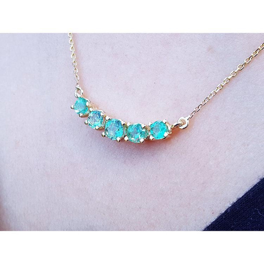 14K gold necklace with five sparkling round-cut medium light green Colombian emeralds.