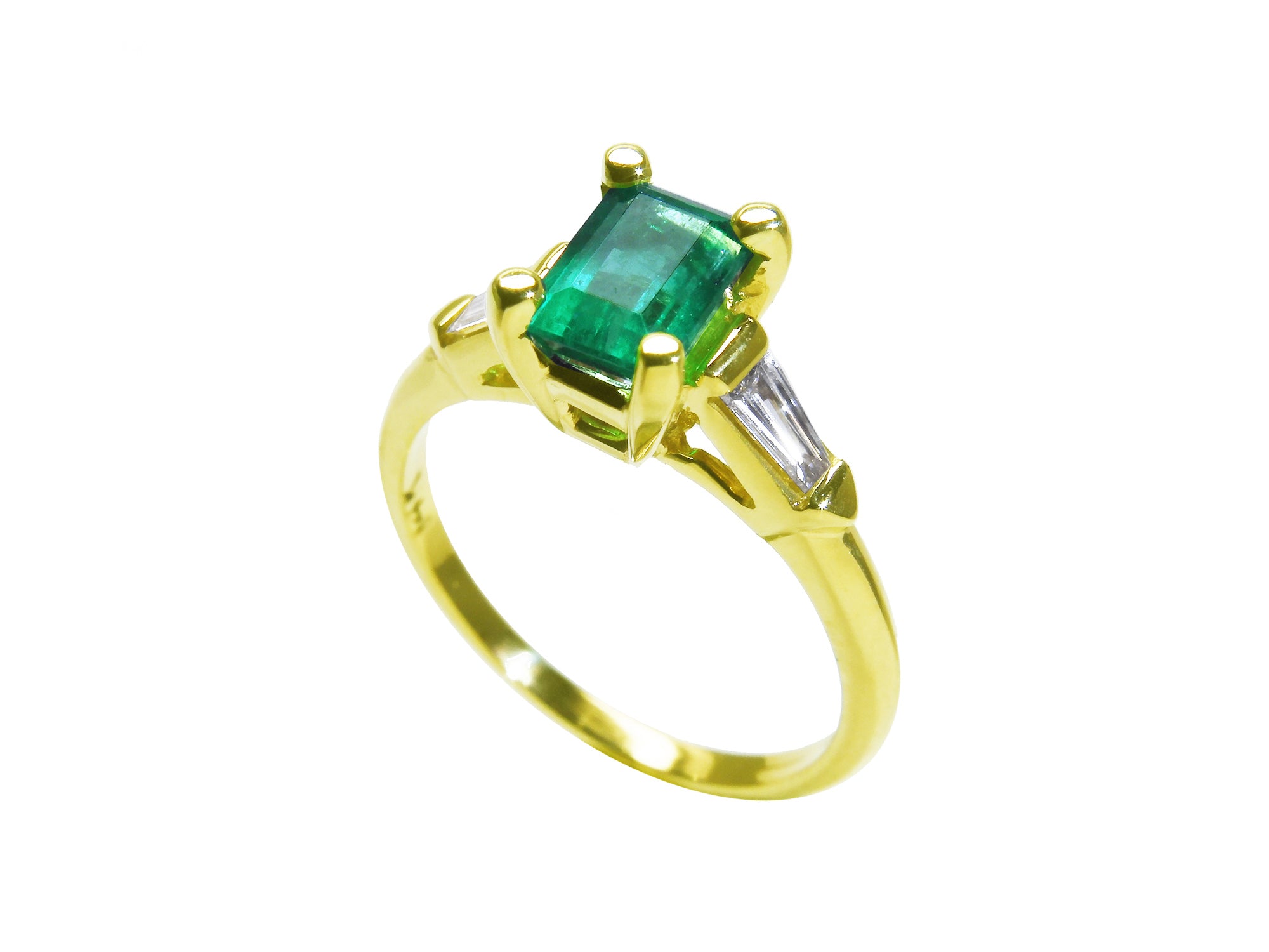The tilted position of this emerald ring shows the top gemstone, side diamond and band profile.
