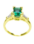 A yellow gold emerald ring displaying its lateral profile, top and gallery view.