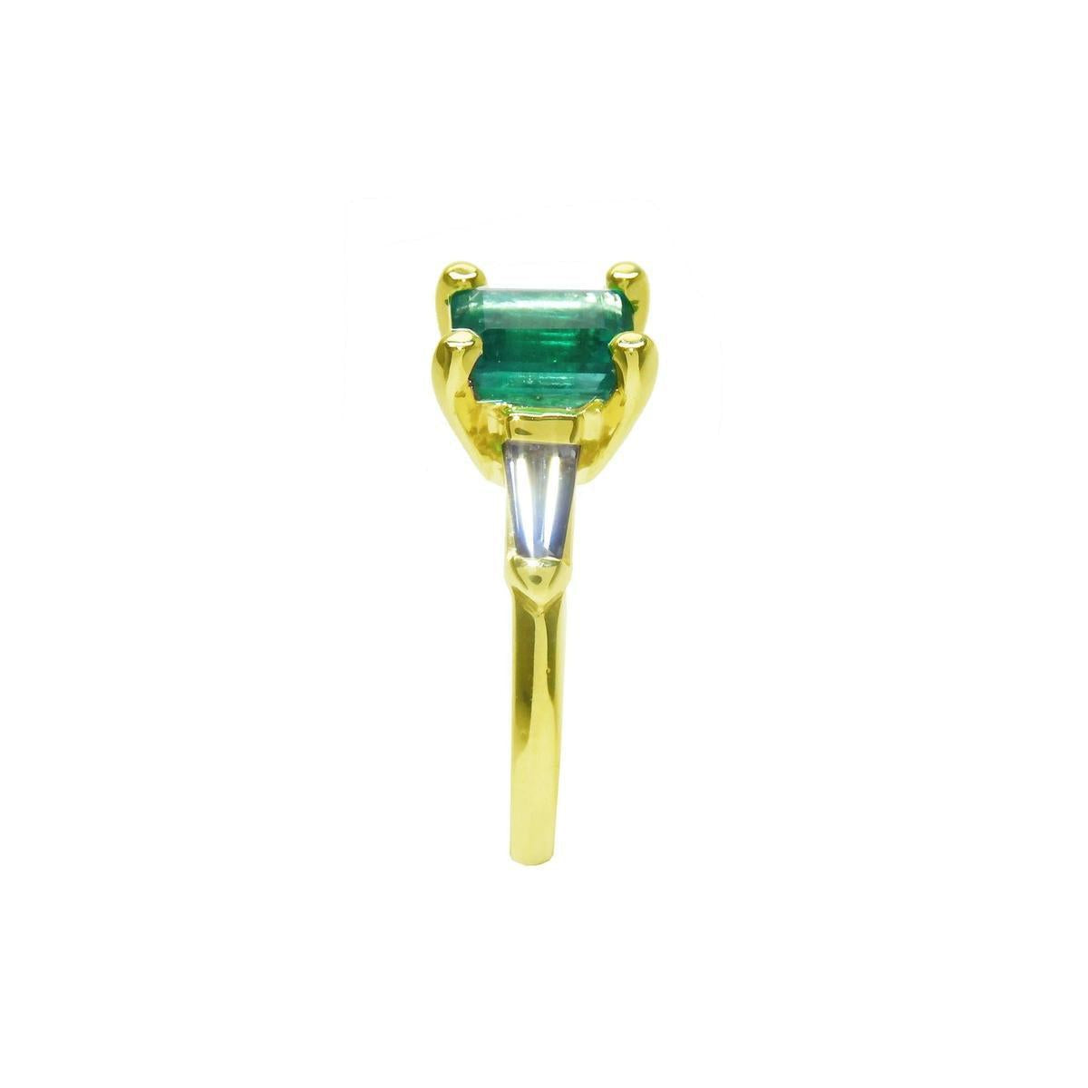 The side profile of this emerald ring displays the top setting, side tapered baguette diamond and band ring.