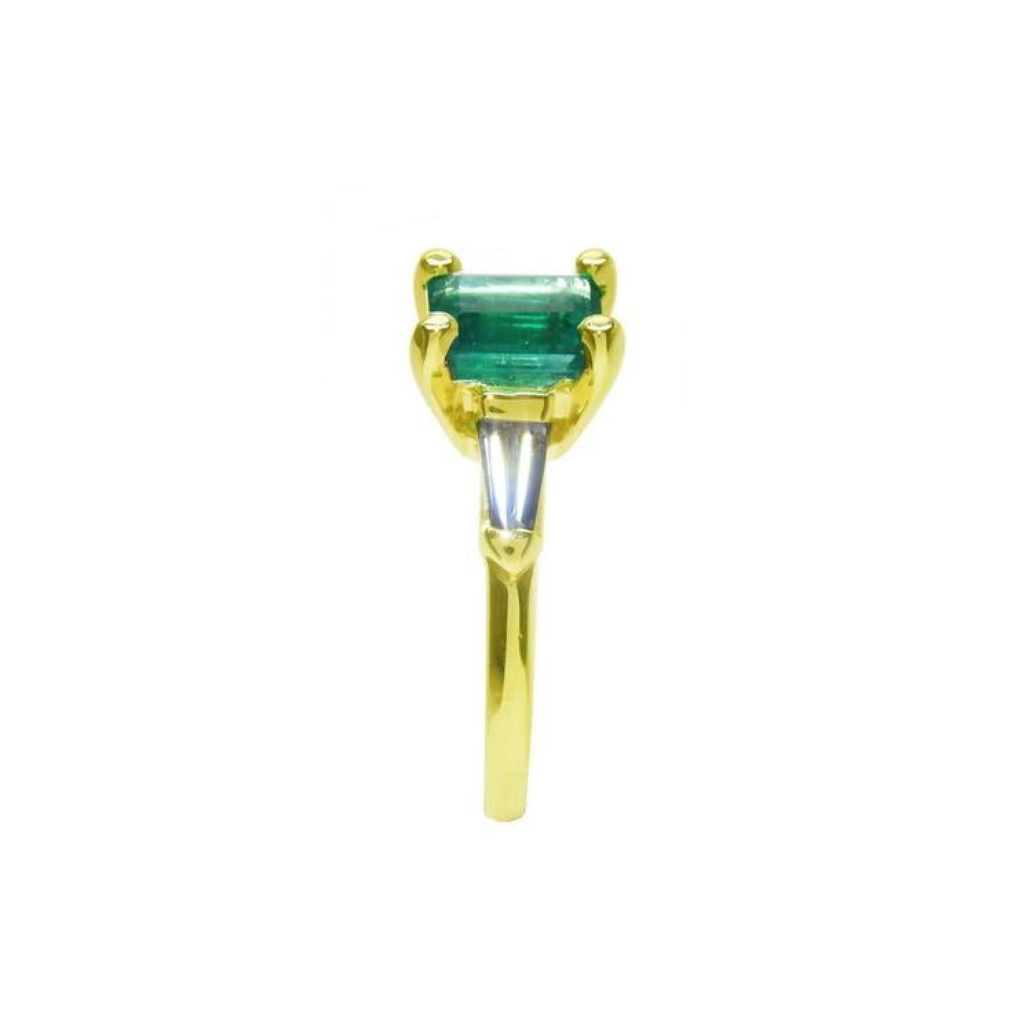 14K yellow gold ring with a rectangular emerald and baguette side diamonds.