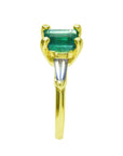 The side profile of this emerald ring displays the top setting, side tapered baguette diamond and band ring.