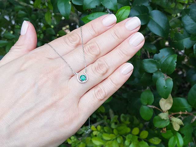 Horseshoe emerald diamond necklace