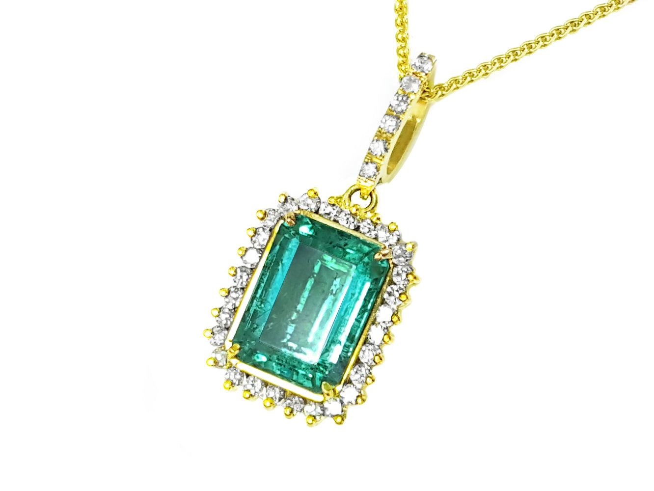 Gold pendant with a natural emerald and diamond accents on a white background.