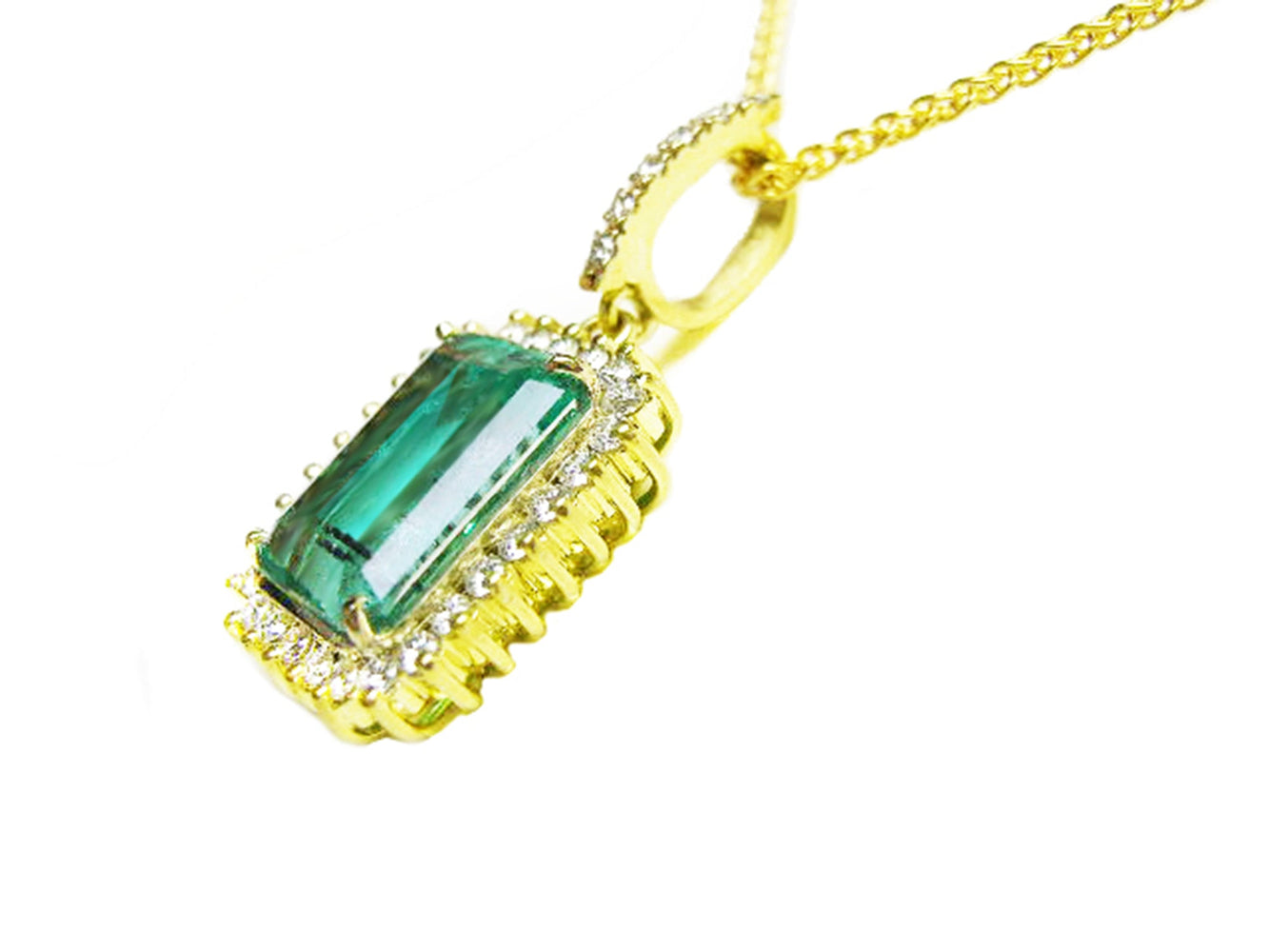 The left side profile of a natural colombian emerald pendant in yellow gold,