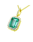 Emerald-cut emerald pendant with halo diamonds in 18K yellow gold, featuring a diamond-set bail.