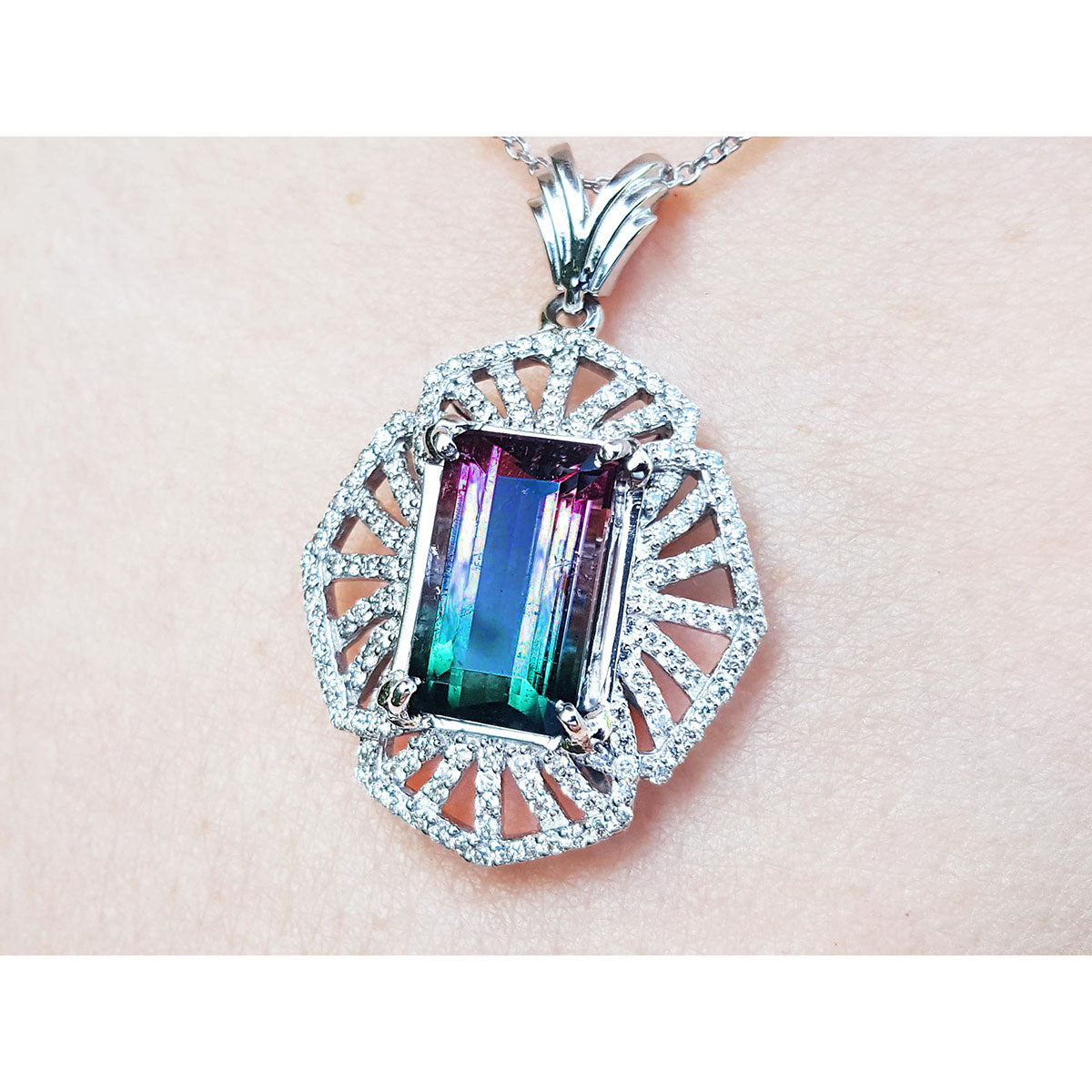 A close-up of a natural tourmaline watermelon pendant in white gold and diamonds.