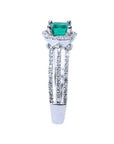 A side profile perspective of this natural emerald ring crafted in 14K white gold. and diamond-studded band.