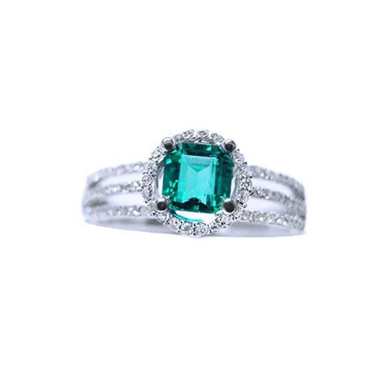 An affordable emerald engagement ring and diamond-studded band crafted in 14k white gold.