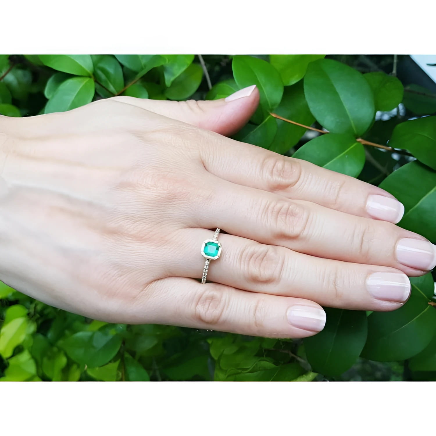14K yellow gold ring with a medium green Colombian emerald in a tapered bezel, accented with natural diamonds.