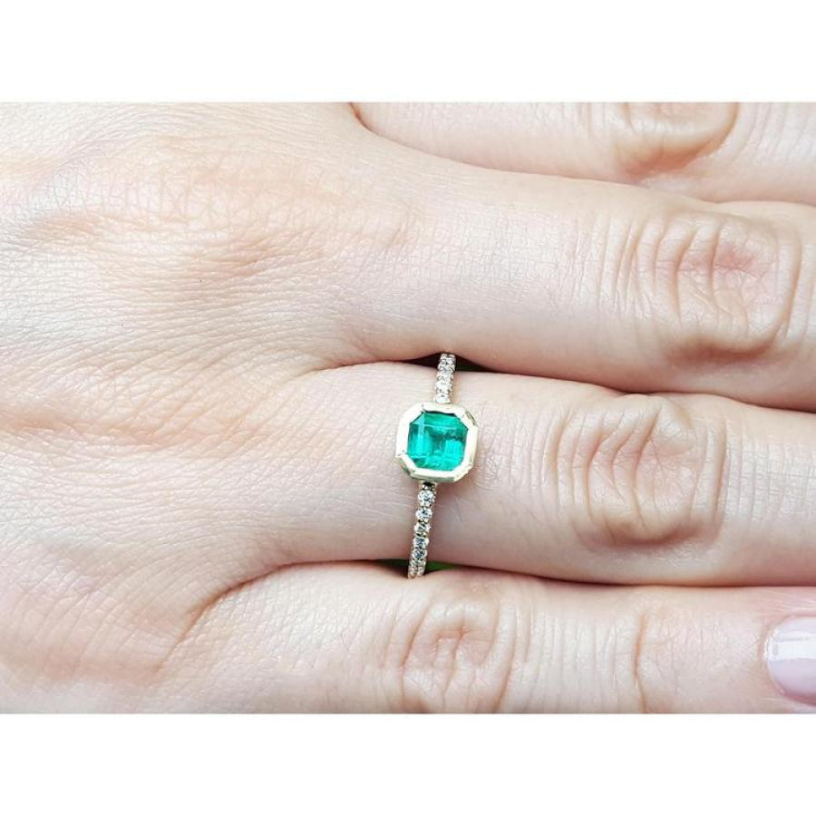 14K yellow gold ring with a medium green emerald in a tapered bezel, flanked by natural diamonds.